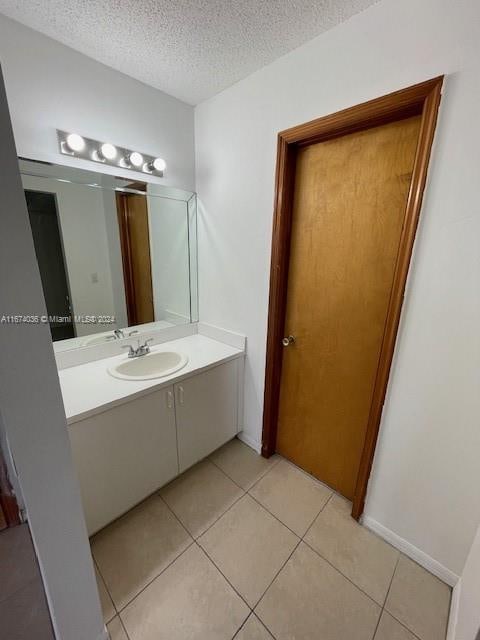 bathroom featuring tile patterned floors, vanity, and a textured ceiling