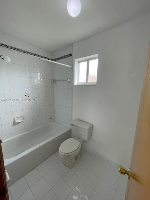 bathroom featuring tile patterned floors, toilet, and tiled shower / bath combo