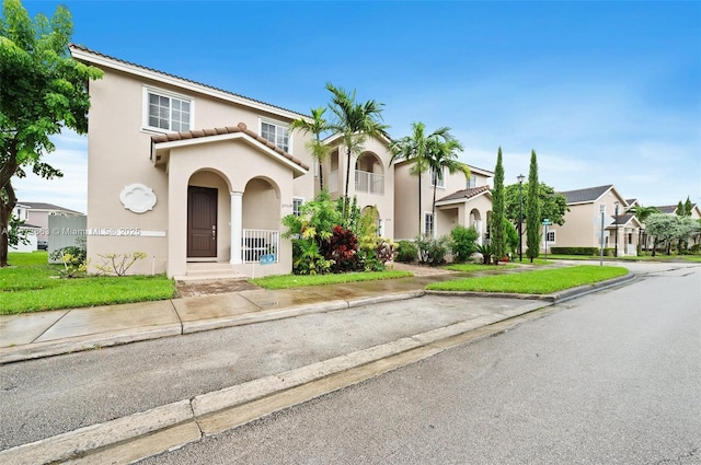 mediterranean / spanish-style home featuring a front yard and a porch