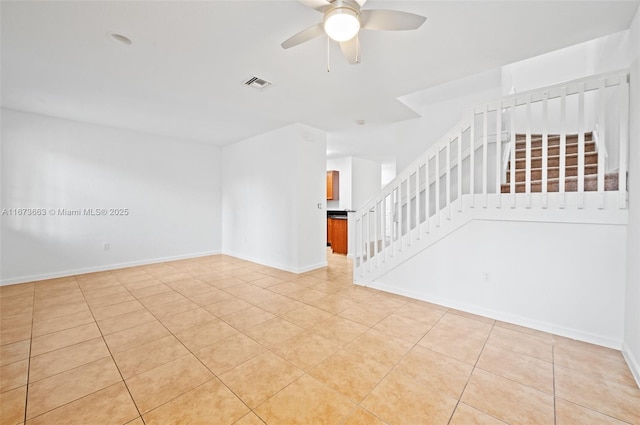 tiled spare room featuring ceiling fan