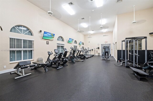 exercise room featuring a towering ceiling