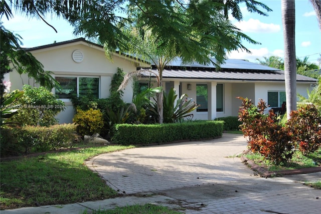 view of front of property featuring solar panels