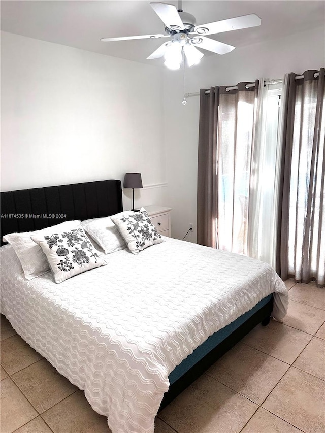 tiled bedroom featuring ceiling fan