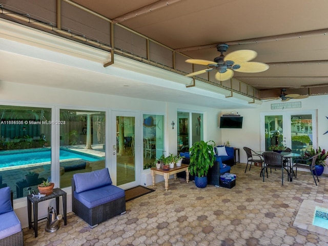 sunroom / solarium featuring ceiling fan and french doors