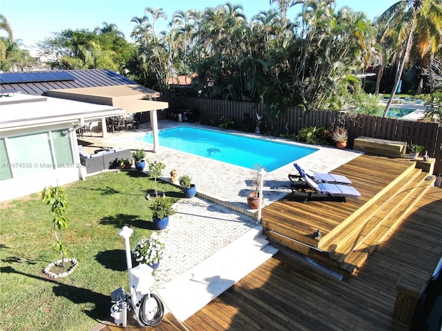 view of swimming pool featuring a hot tub, a lawn, a patio area, and a deck