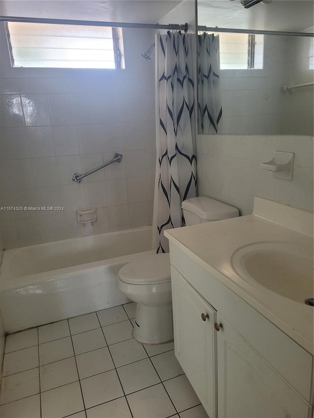 full bathroom with vanity, shower / tub combo, tile patterned floors, tile walls, and toilet