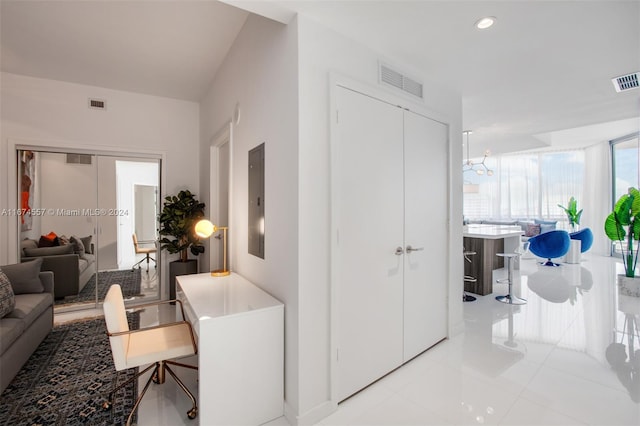 hallway featuring electric panel, a chandelier, and light tile patterned floors