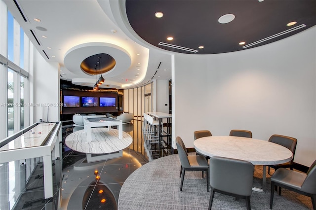 tiled dining space with a raised ceiling