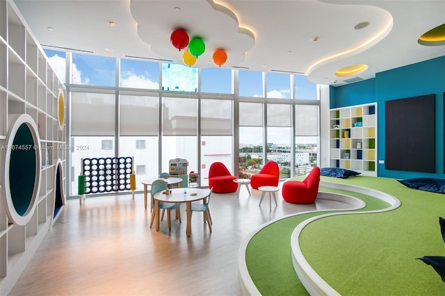 game room featuring expansive windows and light hardwood / wood-style flooring