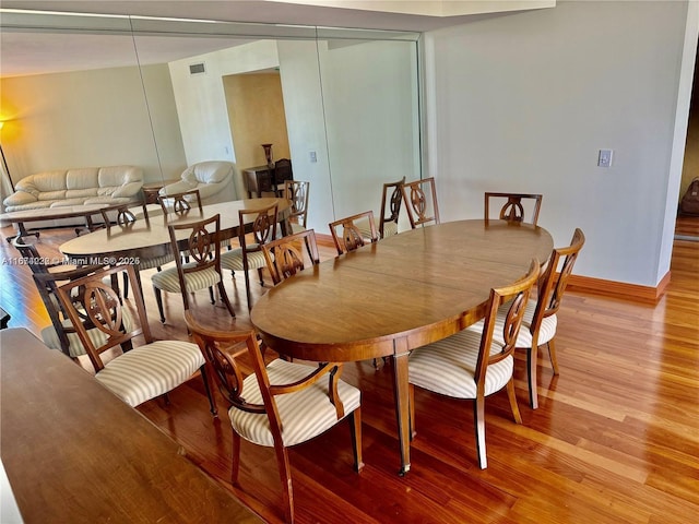 dining area featuring visible vents, light wood-style flooring, and baseboards