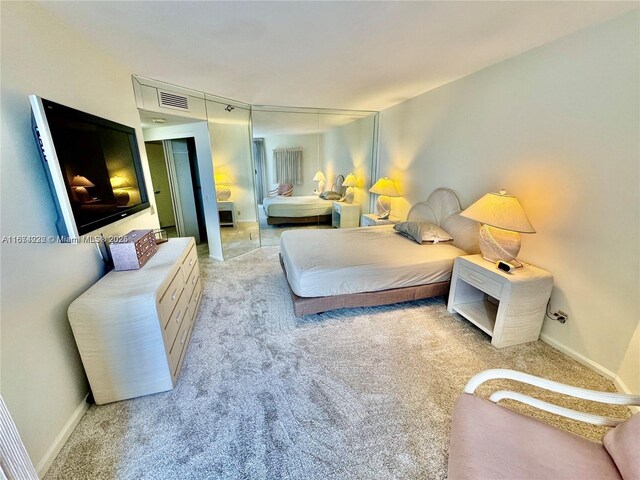 bedroom featuring baseboards, visible vents, and light colored carpet