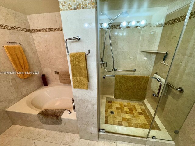 bathroom with tile walls and independent shower and bath