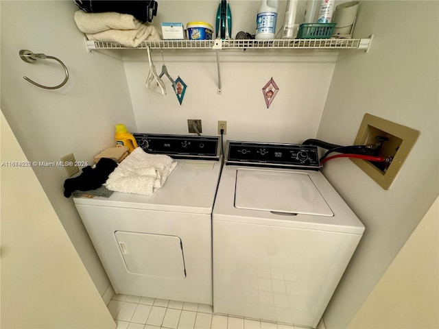 laundry room with laundry area, washer and dryer, and tile patterned floors