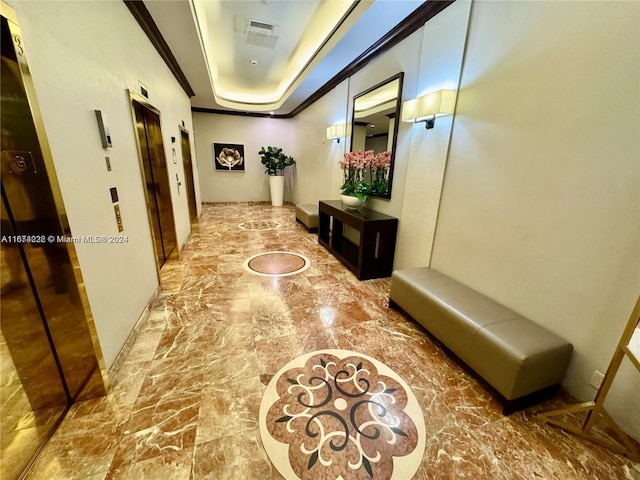 hallway featuring ornamental molding and a tray ceiling