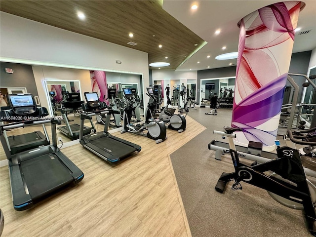 exercise room with wood finished floors, visible vents, and recessed lighting