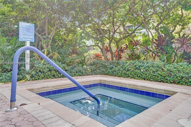 view of swimming pool featuring a hot tub