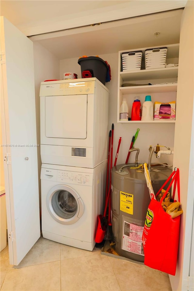 clothes washing area featuring water heater, stacked washer / dryer, and light tile patterned floors