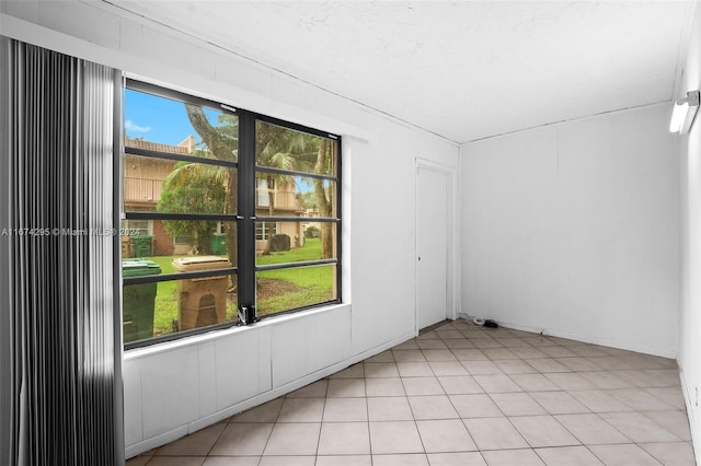 tiled empty room featuring plenty of natural light