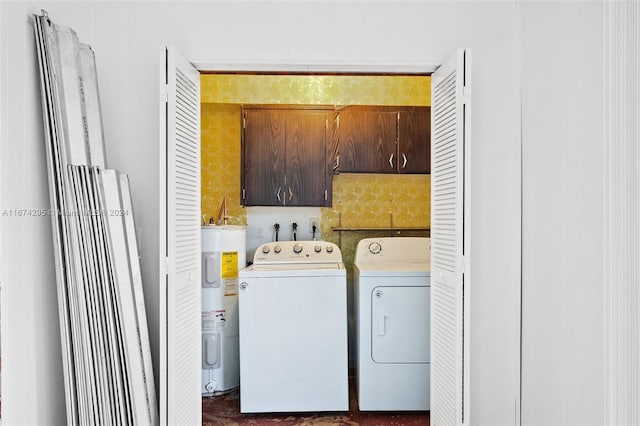 clothes washing area with cabinets, electric water heater, and washer and clothes dryer