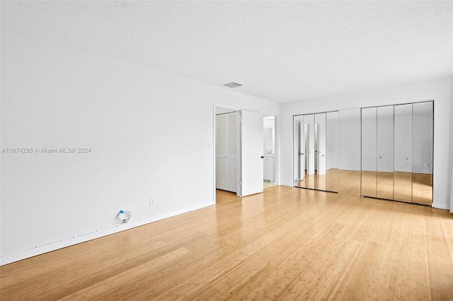 unfurnished bedroom featuring light hardwood / wood-style floors and a textured ceiling