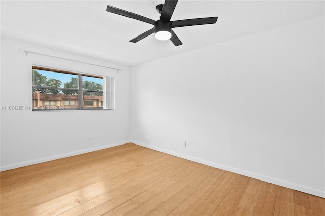 spare room featuring ceiling fan, hardwood / wood-style floors, and a textured ceiling