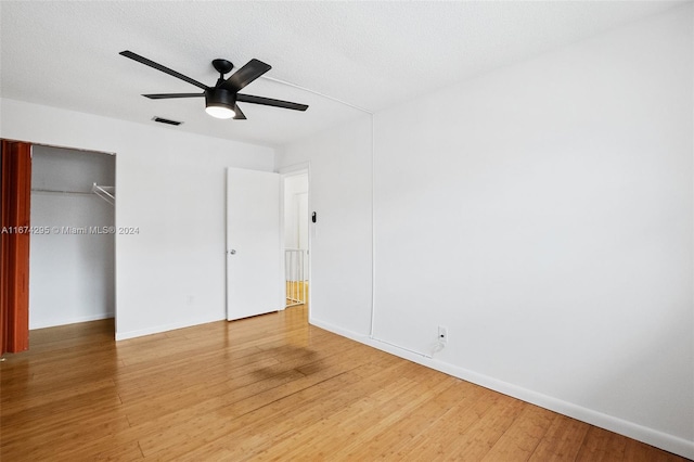 unfurnished bedroom with a closet, hardwood / wood-style floors, a textured ceiling, and ceiling fan