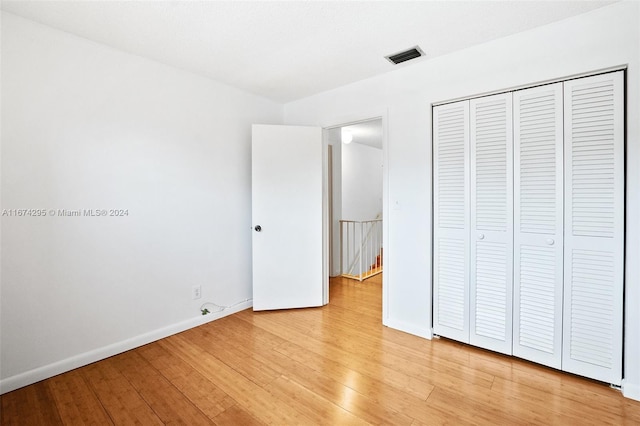 unfurnished bedroom with a closet and light hardwood / wood-style floors