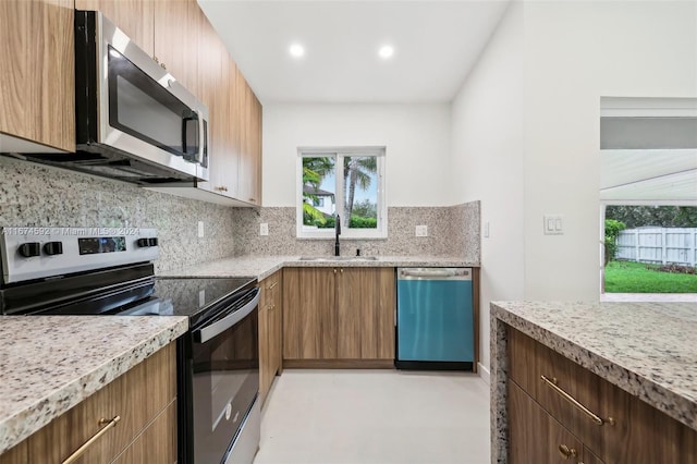 kitchen featuring stainless steel appliances, sink, and tasteful backsplash