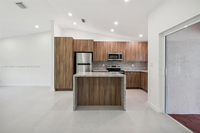 kitchen with appliances with stainless steel finishes, a kitchen island, vaulted ceiling, and backsplash