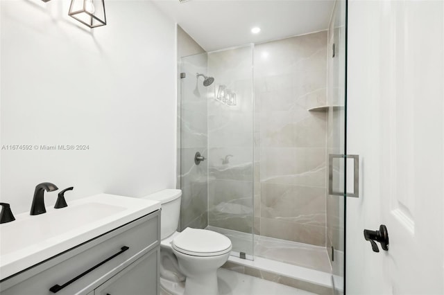 bathroom featuring vanity, toilet, and a shower with shower door