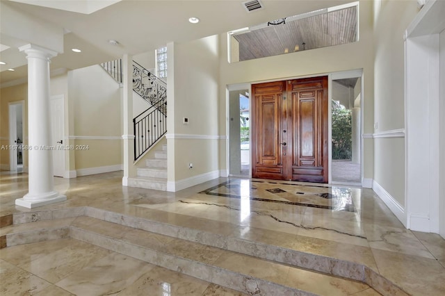 foyer entrance featuring ornate columns and a high ceiling