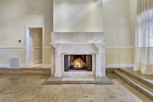 interior details with visible vents, baseboards, and a premium fireplace