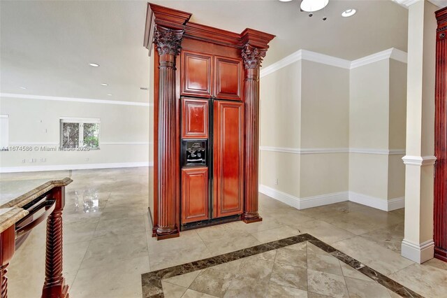 kitchen with light stone countertops, black appliances, ornate columns, ornamental molding, and backsplash