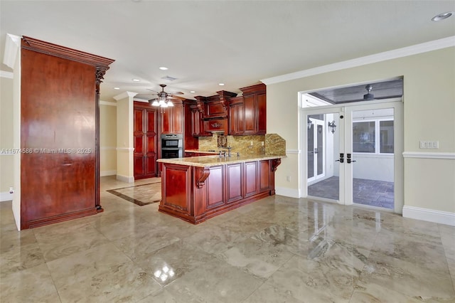 kitchen with reddish brown cabinets, crown molding, a peninsula, and baseboards