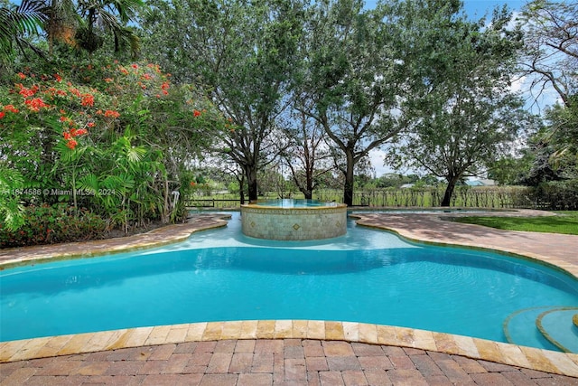 view of swimming pool featuring an in ground hot tub and a patio area