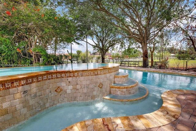 view of swimming pool featuring fence