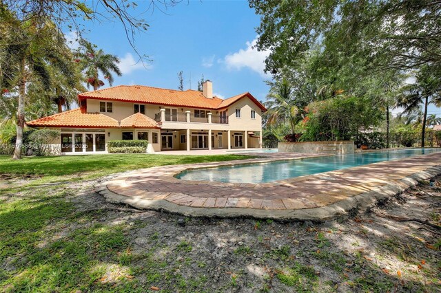 rear view of house with a lawn and a patio area