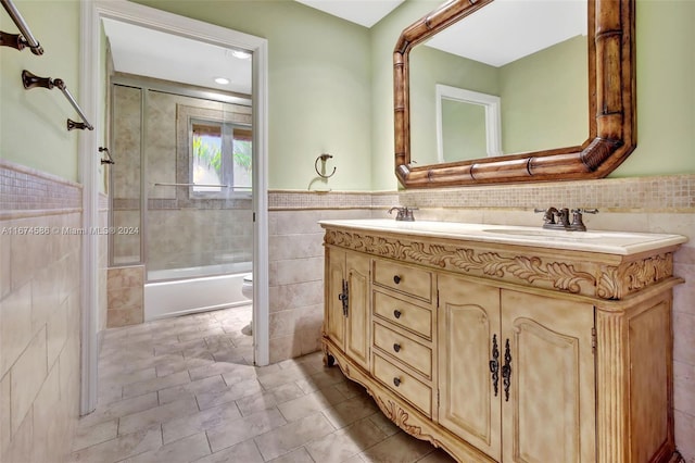 full bathroom with vanity, tiled shower / bath combo, tile patterned floors, tile walls, and toilet