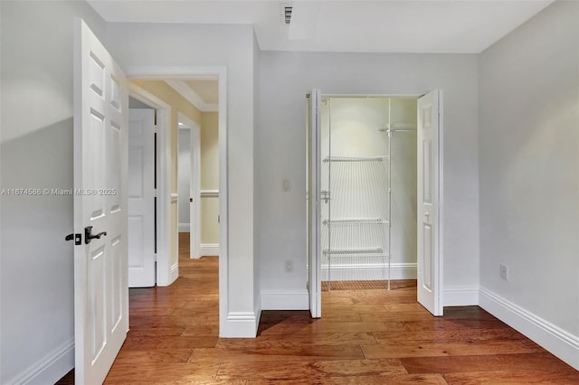 unfurnished bedroom featuring a closet, baseboards, and wood finished floors