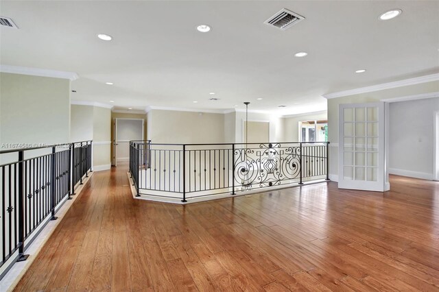 corridor featuring light wood-type flooring and ornamental molding