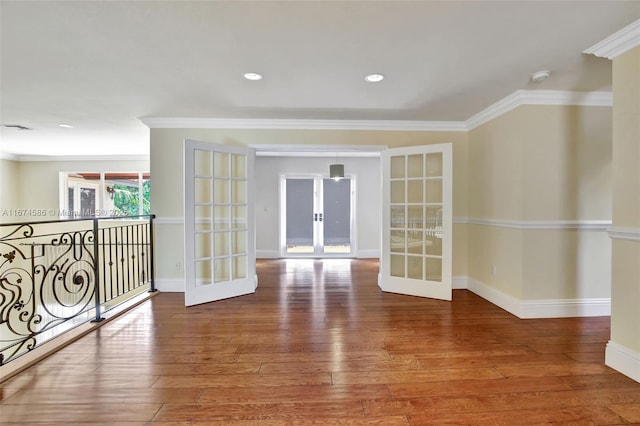 unfurnished room featuring crown molding, wood finished floors, and french doors