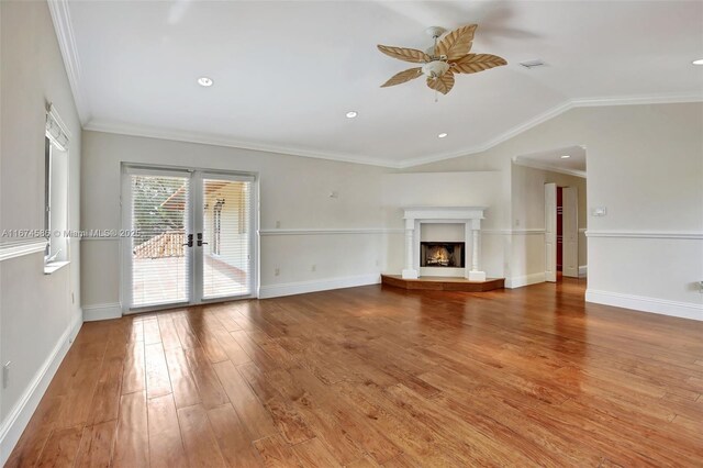 unfurnished living room featuring wood-type flooring, ornamental molding, vaulted ceiling, and ceiling fan