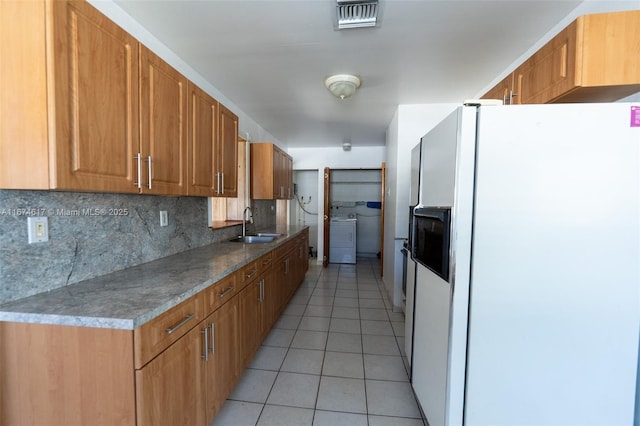 kitchen with backsplash, white refrigerator with ice dispenser, sink, and light tile patterned floors