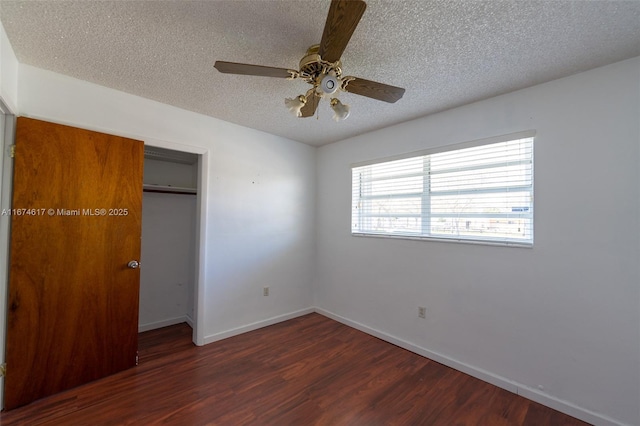 unfurnished bedroom with dark wood-type flooring, ceiling fan, a closet, and a textured ceiling