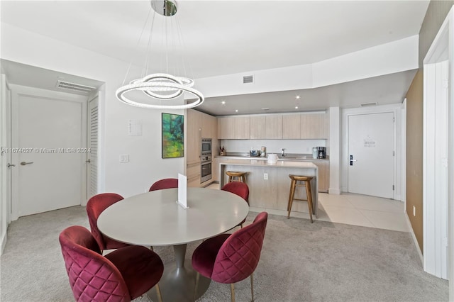 dining room with light colored carpet and a notable chandelier