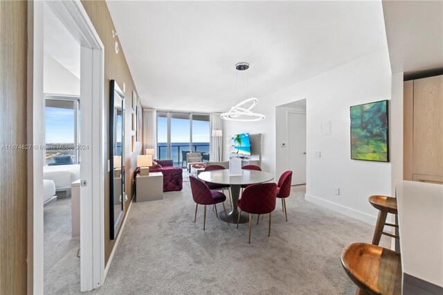 dining area featuring a notable chandelier and light carpet