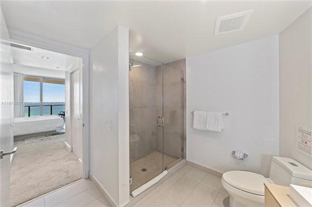 bathroom featuring a water view, vanity, tile patterned floors, a shower with shower door, and toilet