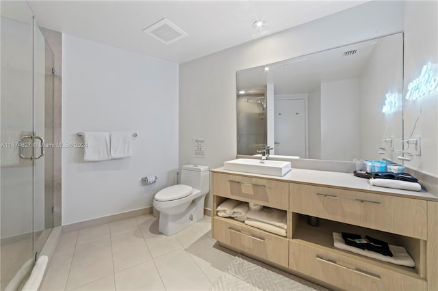 bathroom featuring toilet, tile patterned flooring, vanity, and a shower with shower door