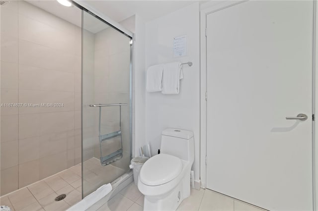 bathroom featuring toilet, an enclosed shower, and tile patterned floors