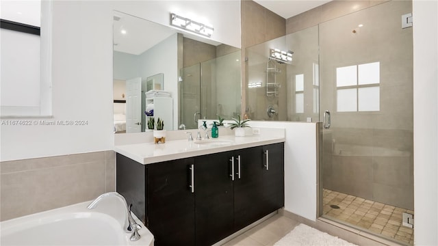 bathroom featuring vanity, plus walk in shower, and tile patterned flooring